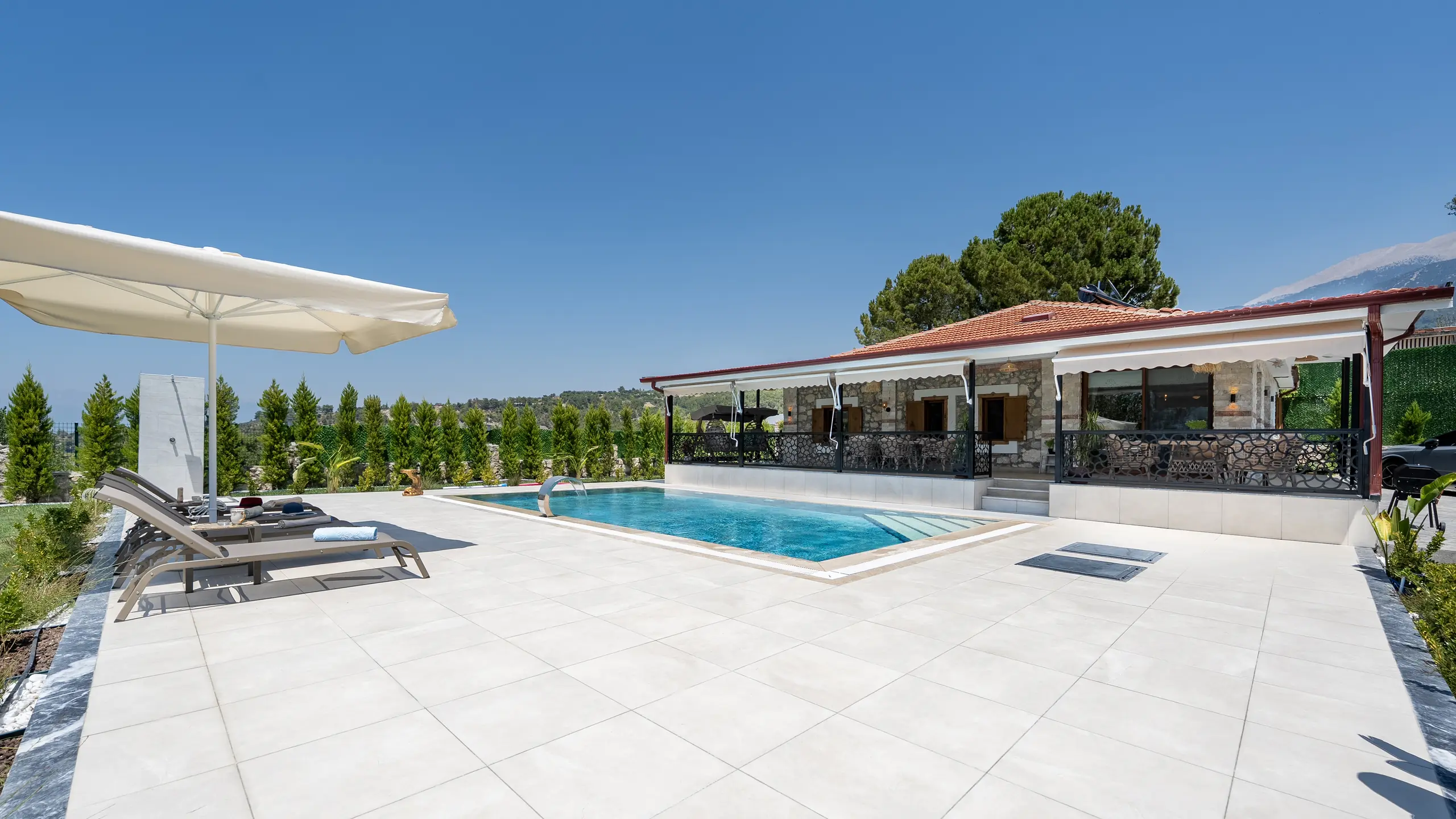 Gün batımında havuz ve ışıklı villa